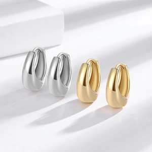 Polished thick teardrop hoop earrings set in gold and silver finish with buckle closure