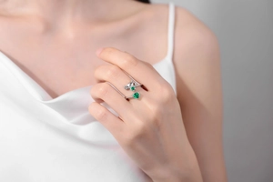 Close-up of adjustable silver axolotl ring featuring a vibrant green heart gemstone