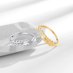 Elegant gold and silver wheat ear open rings displayed on a white stone background