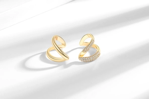 Close-up of gold twisted rings featuring polished metal and micro-paved sparkling crystals