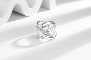 Detail view of silver X-shaped layered ring with micro-paved white zircons and polished finish