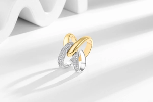 Detail of interlocking gold and silver rings with cubic zirconia pave setting in X-shape