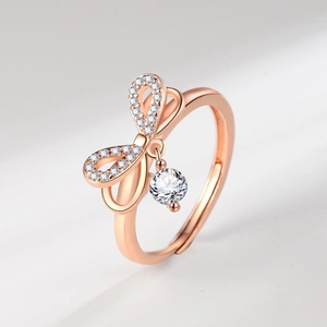Elegant rose gold bow ring with shimmering pavé diamonds and a sparkling zircon drop