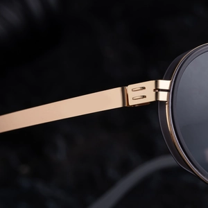 Macro shot of durable golden metal hinges and black frame detail on sunglasses
