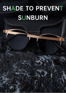 Polarized oval sunglasses with gold frame on leather case and textured rocks