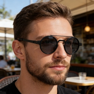 Close-up of matte black round metal sunglasses with double bridge on male model