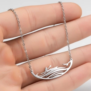 Collier avec pendentif vague en acier inoxydable poli présenté sur la main