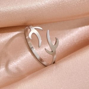 Macro shot of silver deer antler open ring on luxury champagne silk fabric