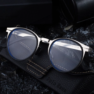 Retro oval polarized sunglasses with black frames and silver metal bridges on rock background