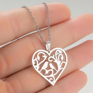 Vue détaillée du pendentif creux en forme de cœur avec des motifs d'oiseaux et de fleurs