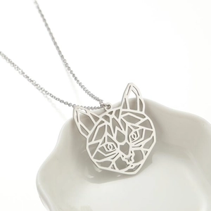 Minimalist stainless steel cat head necklace with geometric cutout pendant on a tray