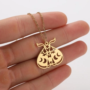 Detailed close-up of a gold-plated moth pendant featuring hollowed geometric patterns