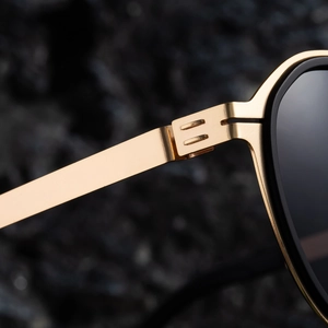 Close-up of golden metal hinge and parallel bar detail on polarized sunglasses