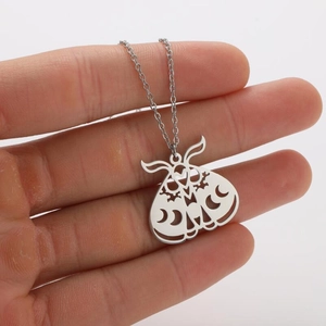 Close-up of silver moth pendant with hollow crescent moon details on stainless steel chain