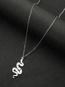 Detailed view of a silver snake pendant with moon and star engravings on a dark surface