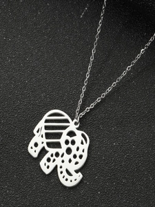 Macro detail of silver elephant pendant with hollow design on black textured background