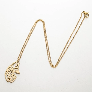 Détail d'un pendentif tête de renard doré avec nœud celtique sur une chaîne fine