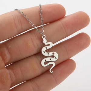 Detailed view of silver snake pendant with engraved moon and stars on a steel chain