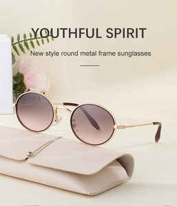 Détail de lunettes de soleil rondes en métal avec verres dégradés et étui en cuir