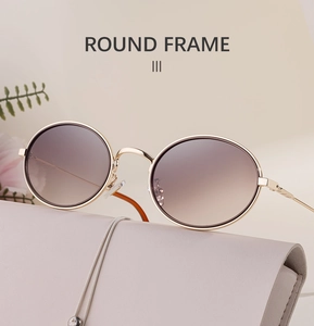 Détail de lunettes de soleil ovales vintage avec monture dorée et verres dégradés