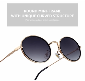 Détail de lunettes ovales en métal avec pont doré et verres dégradés gris foncés