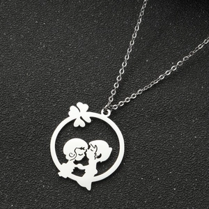 Détail du pendentif silhouette couple en argent avec trèfle sur fond noir pailleté