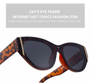 Detailed close-up of leopard cat eye sunglasses with gold trim and dark grey lenses