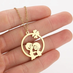 Détail du collier en acier inoxydable doré avec pendentif rond silhouette couple baiser