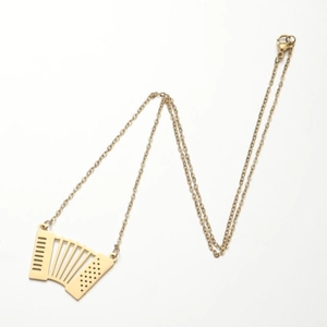 Détail macro d'un collier avec pendentif accordéon doré montrant les soufflets et touches