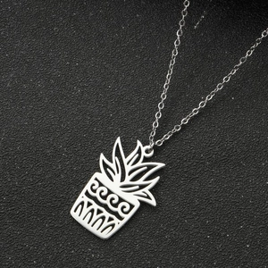 Macro shot of silver stainless steel necklace with hollow potted plant leaf pendant