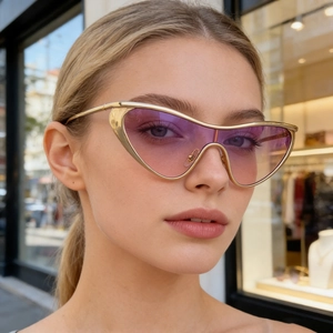 Detailed view of oversized gold cat-eye sunglasses with purple gradient lenses on a model