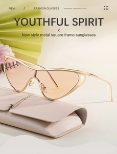 Detail of cat eye sunglasses with gold metal frame on a beige leather glasses case