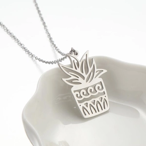 Minimalist silver stainless steel necklace with plant pot leaf pendant on white plate