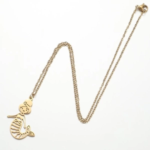 Detailed view of an 18K gold mermaid pendant with hollow lines on a dainty cable chain