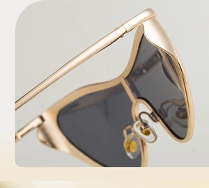 Detailed close-up of light gold metal frame and soft silicone nose pads on sunglasses