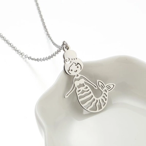 Elegant 18K gold-plated silver mermaid pendant necklace on a ceramic jewelry tray