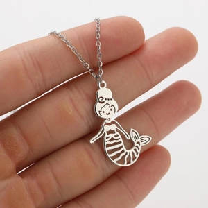 Close-up of a silver hollow mermaid pendant with fine link chain held in hand