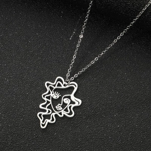 Macro detail of abstract face line art pendant on a stainless steel link chain