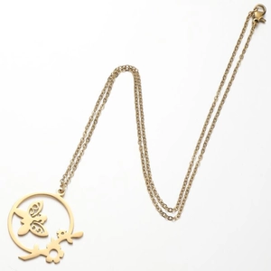 Nahaufnahme der goldenen Halskette mit rundem Anhänger aus Libellen- und Blumenmuster