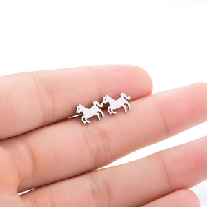 Detail of small stainless steel horse stud earrings held on a finger for size reference