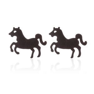 Detail of matte black horse silhouette stud earrings in stainless steel on white surface