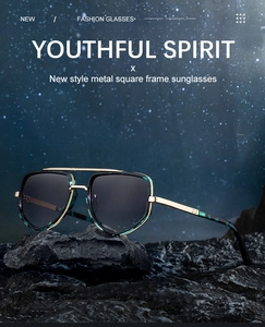 Détail de lunettes de soleil carrées avec double pont doré sur base rocheuse