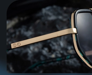 Détail de la charnière en métal doré et de la monture en acétate vert foncé pour lunettes