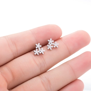 Macro shot of silver stainless steel floral stud earrings showing small flower details