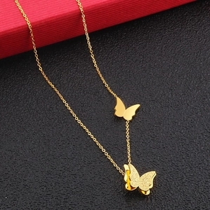 Detail of gold Y-necklace featuring matte and polished butterfly pendants for women