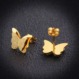 Detailed macro of gold butterfly earrings with frosted and polished double-layer wings