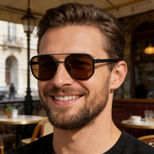 Close-up of polarized pilot sunglasses with brown lenses on male model in outdoor cafe