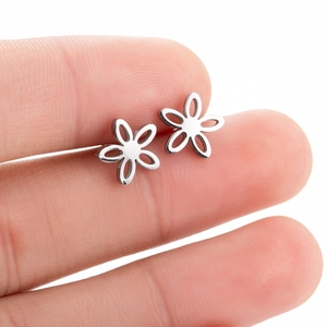 Minimalist hollow flower stud earrings in silver steel held between fingers for size