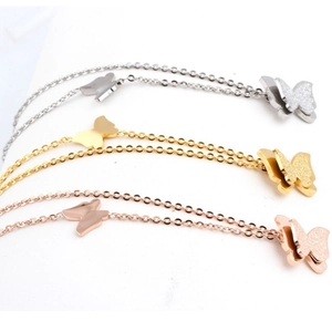 Close-up of double-layered butterfly pendant with frosted finish in three metallic colors