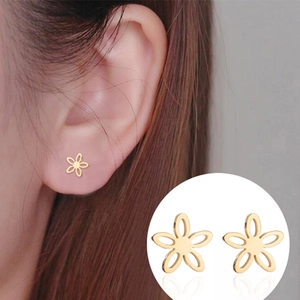 Elegant gold hollow five-petal flower stud earrings for women shown on model